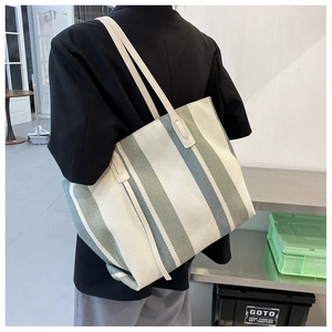 Detailed back view of a vertical striped canvas tote bag with long white shoulder straps