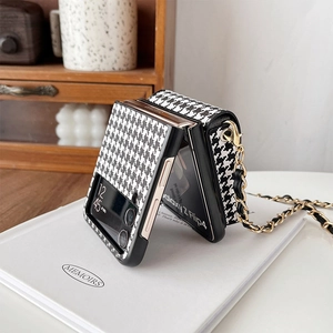 Detail of Galaxy Z Flip4 case featuring houndstooth pattern and leather chain strap