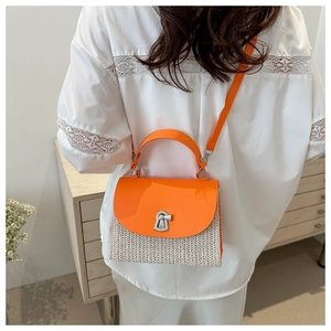 Detail of orange patent leather and straw woven bag with silver metallic swivel lock