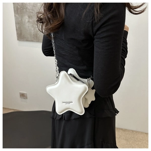 Detailed view of a star-shaped white leather bag with silver chain and star charm