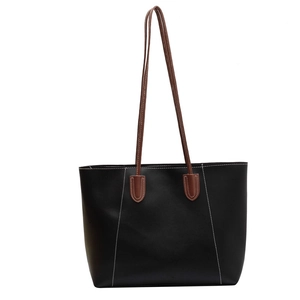 Minimalist black tote bag with brown shoulder straps and contrast white stitching