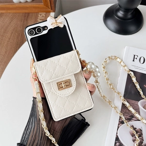 Detail of white quilted leather phone case with butterfly decor, pearl strap and chain