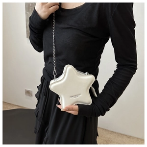 Close-up of a white star-shaped crossbody bag with a silver chain strap and leather texture
