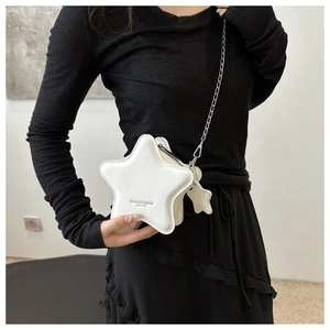 Detail of white star-shaped leather crossbody bag with silver chain and star charm