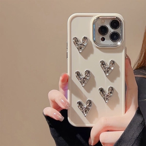 Close-up of cream silicone iPhone case with 3D silver hearts and raised lens protection