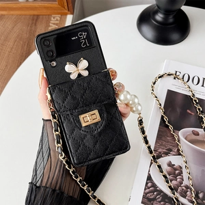 Detail of black quilted leather phone case for Samsung Z Flip with pearl strap and butterfly