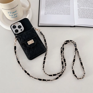 Detail of crossbody iPhone case featuring black quilted leather card slot and gold metal clasp
