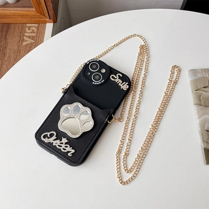 Detail of black leather crossbody phone case with cat paw mirror and gold chain strap
