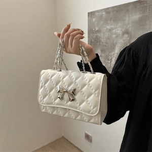 Quilted white crossbody bag with silver bow accent and metal chain strap for women