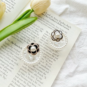 Detail of camellia flower phone grips with pearls on aesthetic vintage book background