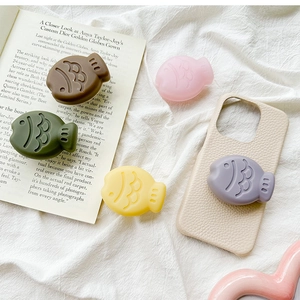 Detailed view of colorful 3D fish-shaped phone grip sockets on a textured leather case