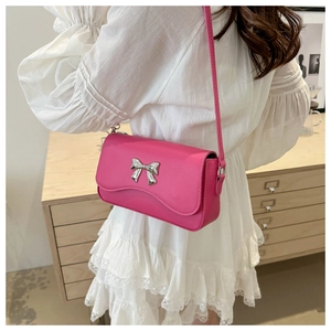 Detailed view of hot pink butterfly crossbody bag worn at waist by a model