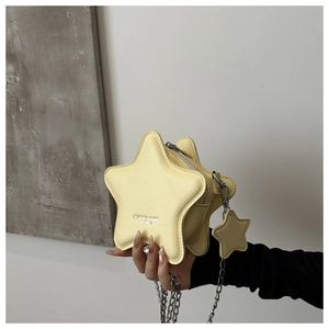 Detailed close-up of yellow star-shaped leather bag with metal chain strap and logo