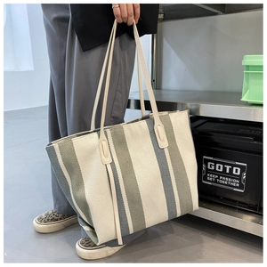 Detailed macro view of the striped canvas tote bag with reinforced stitching handles
