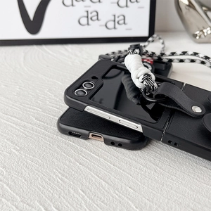 Detail view of black foldable phone case with textured surface and woven strap