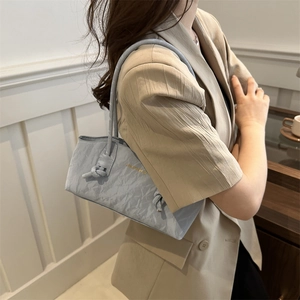 Sac à bandoulière froncé bleu clair avec sangle nouée et logo doré au style épuré