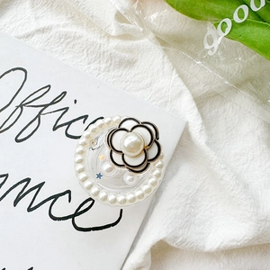 Detail of camellia flower phone grip with pearls and glitter on aesthetic white background