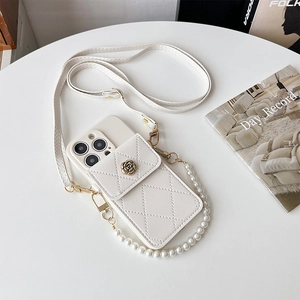 Detail of white quilted phone case with metal flower and decorative pearl chain strap