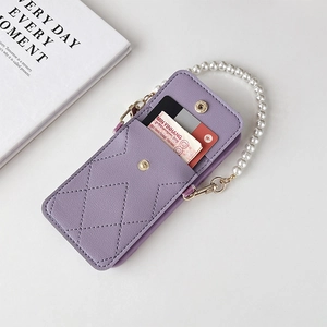 Close-up of purple quilted phone wallet case with pearl strap and gold hardware accents