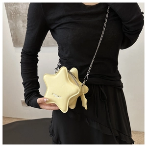Star-shaped yellow leather crossbody bag with silver chain strap shown on a model
