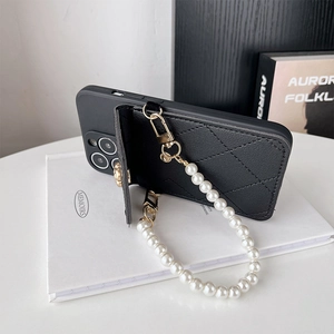 Detail of black quilted leather phone case with flip card wallet and pearl handle