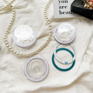 Transparent heart and round folding phone grips with 3M adhesive on white linen background
