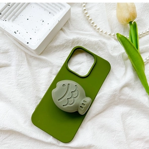Close-up of matte green phone case with 3D fish air cushion stand on decorative tray