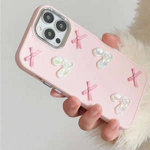 Detail of pink iPhone case with 3D ribbon bows and pearlescent heart charms