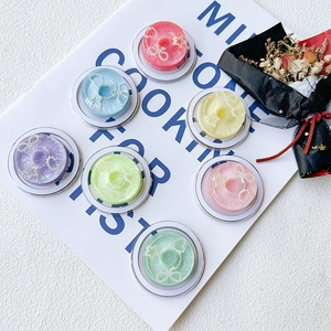 Macro detail of macaron colored eyelash cases with pearl bows and glitter lashes