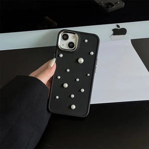 Macro shot of black matte phone case with white pearl accents and silver metal camera frame
