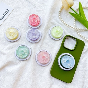 Magnetic donut phone grip with bow and pearl accents in vibrant macaron colors