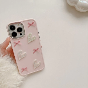 Close-up of pink iPhone case featuring textured 3D bows and iridescent pearl hearts