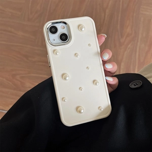 Close-up of cream silicone iPhone case with elegant pearl embellishments held in hand