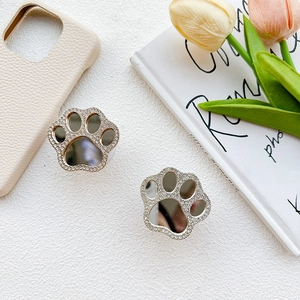 Detail of cute cat paw phone grip with sparkly rhinestones and makeup mirror surface