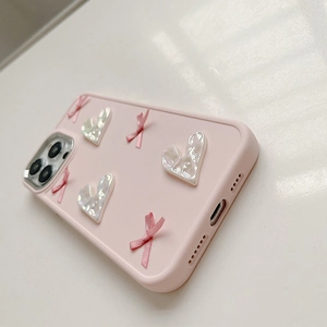 Detailed view of pink iPhone case with 3D pearl hearts and ribbon bow balletcore accents