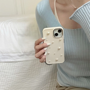 Close-up of elegant cream silicone iPhone case decorated with stylish white pearls