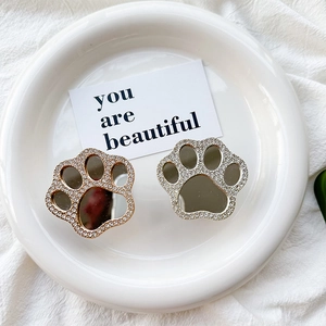 Detail of glittery cat paw phone grip featuring a central mirror and sparkling rhinestones