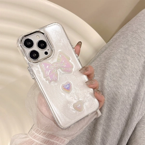 Detail of iPhone case with 3D pink bows and gradient hearts on pearlescent finish