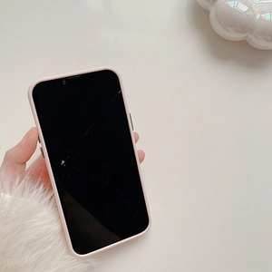 Pink heart crinkle silicone case for iPhone 16 Pro Max shown held over a white desk