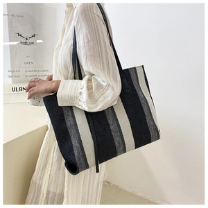 Detailed texture of thick woven fabric on large tote bag with vertical stripes
