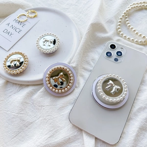 Mirror phone grip with pearl border and bow design on a white phone case