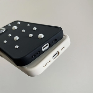 Detail of minimalist silicone phone cases in black and beige with silver pearl accents