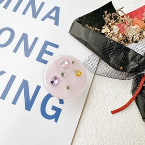 Detail of glittery pink phone grip with multi-colored rhinestones and crystal accents