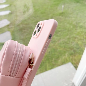 Detailed side view of pink iPhone silicone case with integrated mini zipper pouch and gold clip