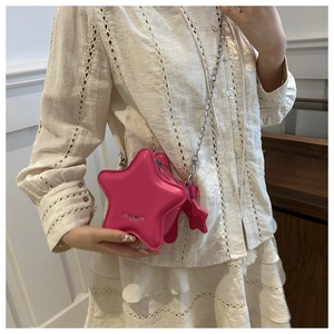 Detail of hot pink star-shaped PU leather crossbody bag with silver chain and star charm