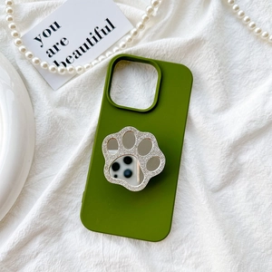 Macro view of rhinestone cat paw mirror phone grip on grass green silicone case