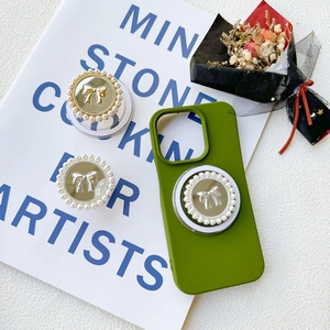 Detail of sage green phone case with pearl-rimmed mirror bow magnetic socket grips