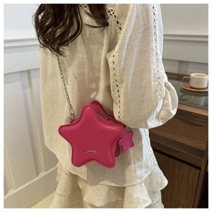 Detail of star-shaped crossbody bag in pink leather with silver chain and star charm