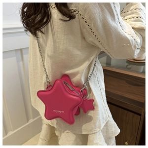 Detail of fuchsia star-shaped leather crossbody bag with chain strap and matching charm