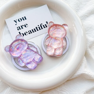 Detail of colorful 3D laser bear phone sockets with foldable grip on a white ceramic tray